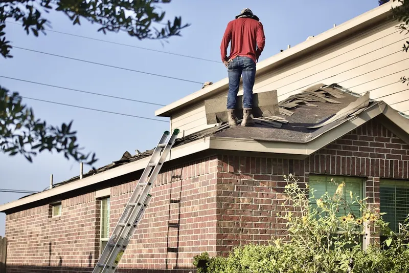 Professional roofer working on a residential roof in West End - West Side
